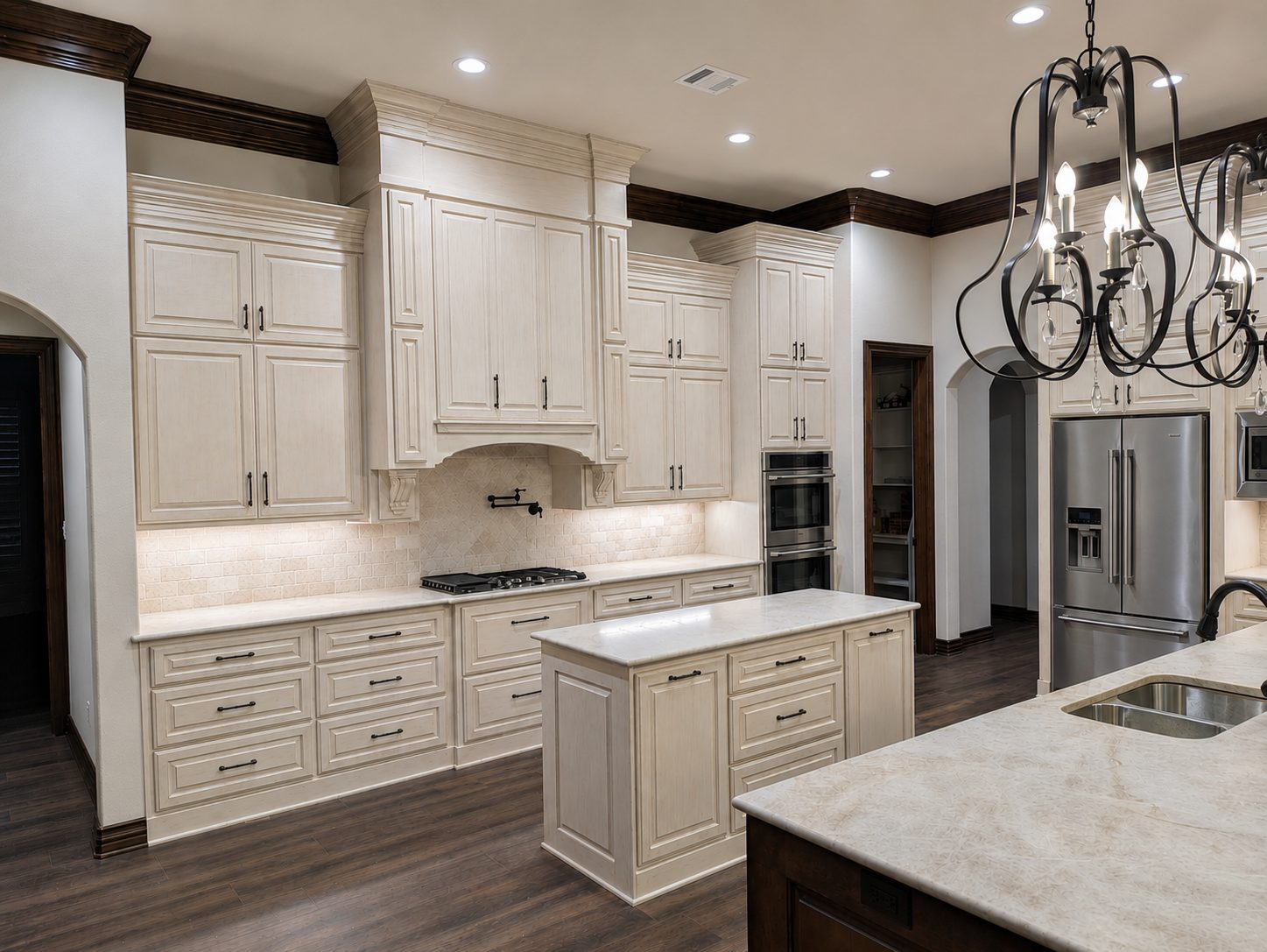 Light finished kitchen cabinets with an iron chandelier
