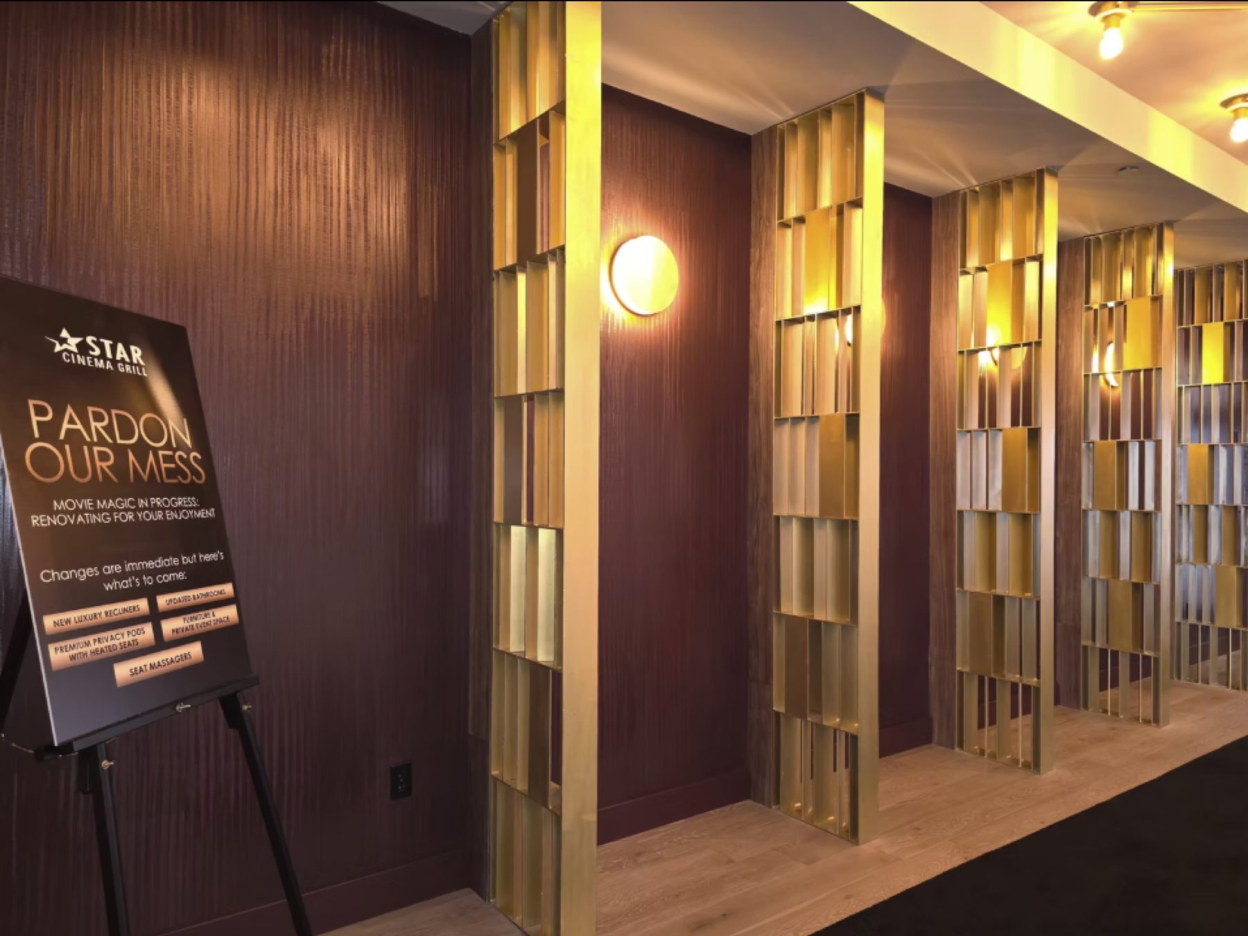 Cinema lobby with burgundy textured walls and gold screens