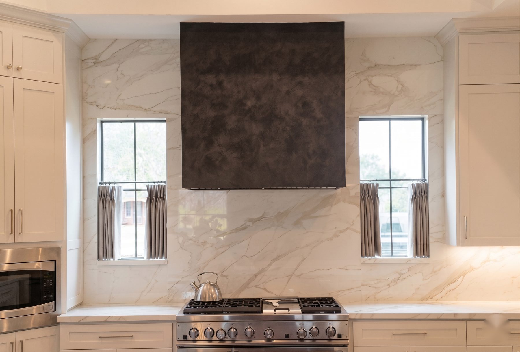 Dark custom plaster range hood in a luxury kitchen